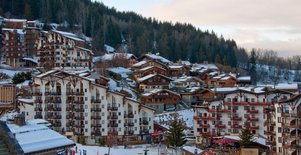 Gros plan sur une façade de chalet traditionnel en bois patiné avec un balcon sculpté et des volets en bois massif